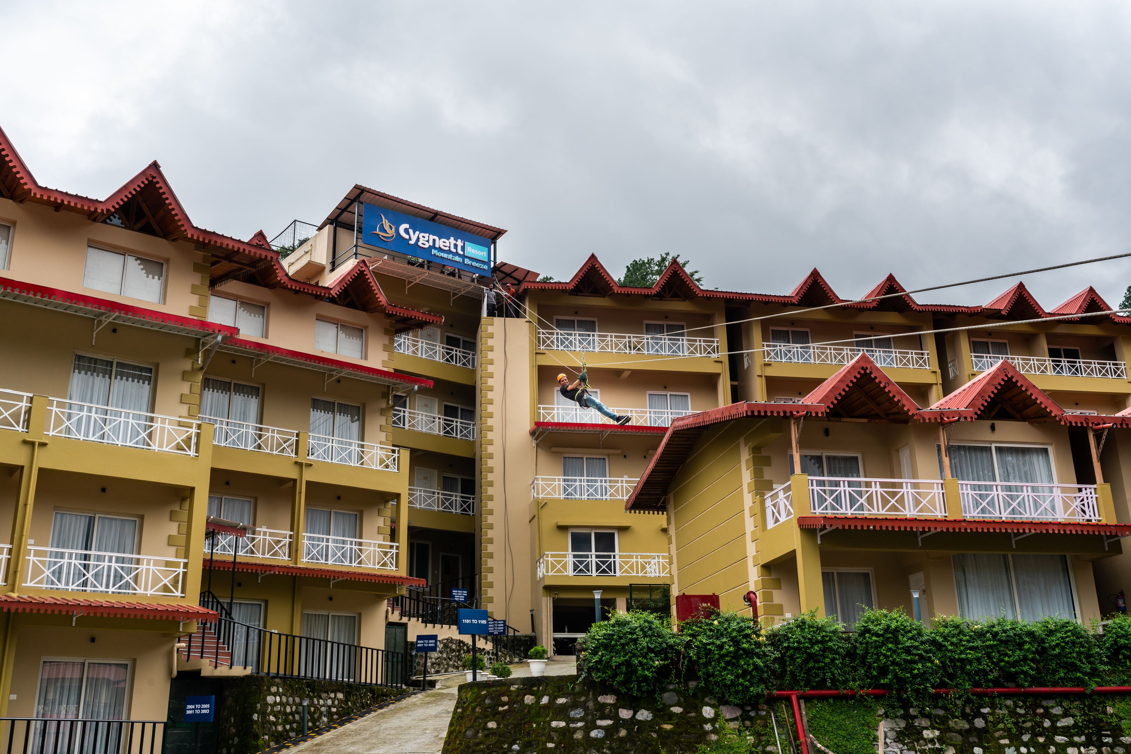 Ein mehrstöckiges Hotel mit Balkonen, einem Schild mit der Aufschrift 'Cynnett Inn' und einer Treppe, die zum Eingang führt.