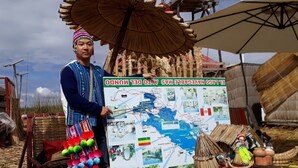 A person holding a map with a large umbrella and colorful decorations.