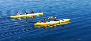 Tres kayaks amarillos sobre aguas tranquilas.