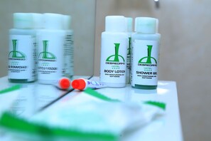 Tocador de baño con diversos artículos de aseo, como loción corporal, gel de ducha y un cepillo de dientes.