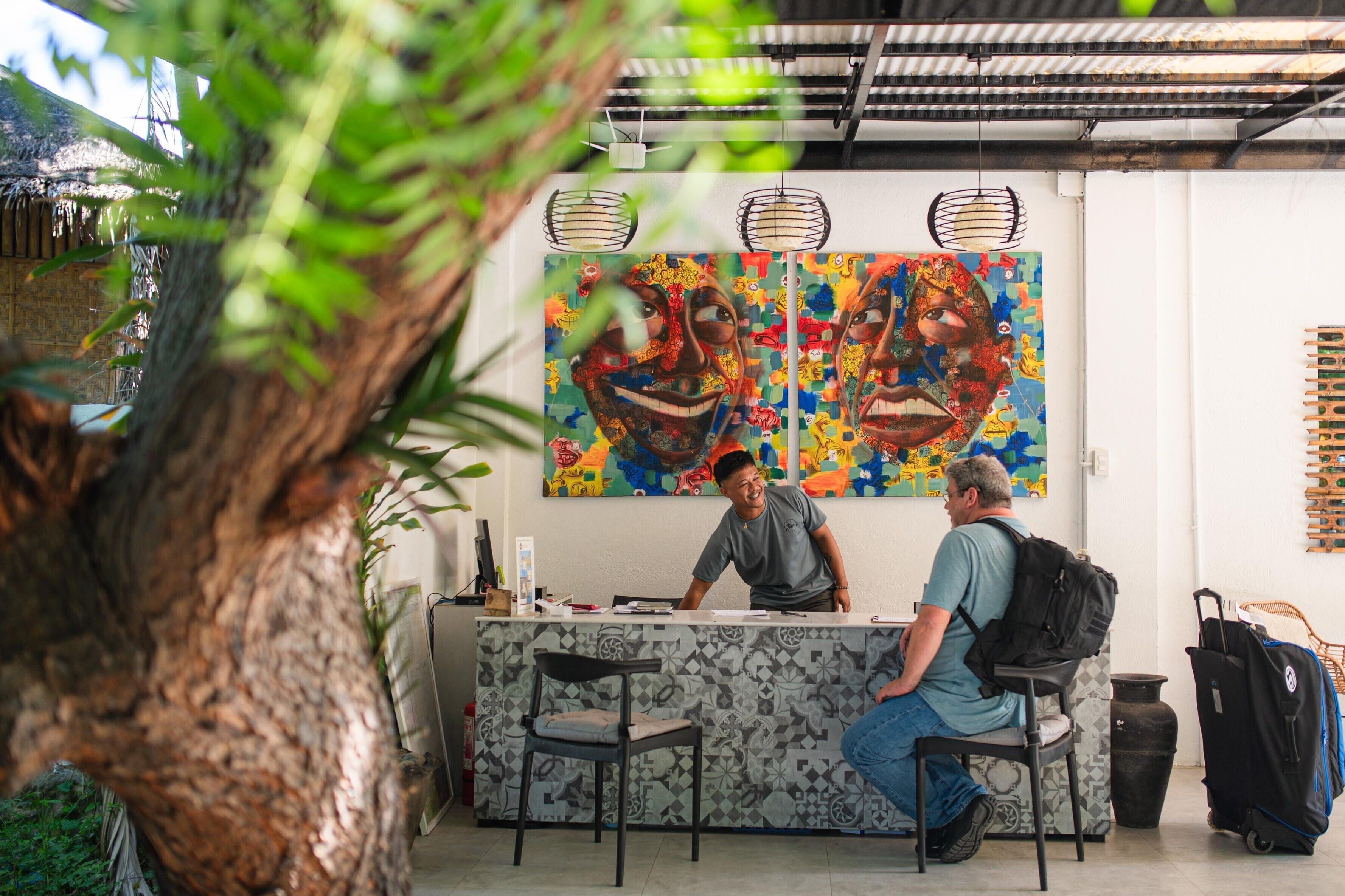 Un área de recepción con mostrador, dos sillas y un cuadro abstracto grande en la pared.