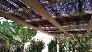 A covered outdoor area with a wooden structure and greenery. - Charming village house in Aix en Provence (Aix en Provence)