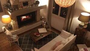 A cozy living room with a fireplace, a sofa, a coffee table, and a lamp. - Charming village house in Aix en Provence (Aix en Provence)
