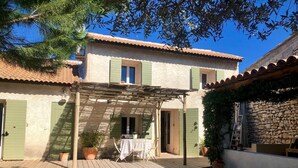 A villa with a swimming pool, wooden deck, and a stone wall. - Charming village house in Aix en Provence (Aix en Provence)