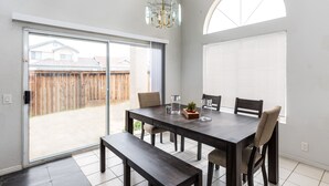 A dining area with a dark wooden table, four chairs, a bench, and a chandelier. - Hill View Home of the High Desert Victorville CA (Victorville)