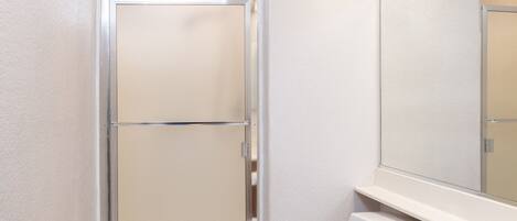 A bathroom with a shower, toilet, and vanity.