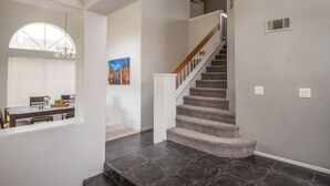 A staircase with carpeted steps and a wooden handrail, leading to an upper floor. - Hill View Home of the High Desert Victorville CA (Victorville)