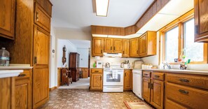 A kitchen with wooden cabinets, a stove, and a sink. - "Mulrooney's" is a ranch style home offering everything on the main level in Lake Mokoma (Laporte)