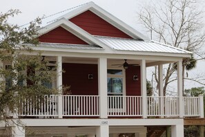 A red and white house with a covered porch and a balcony.