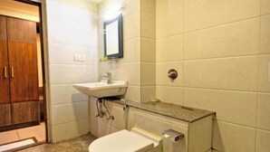 Un baño con inodoro, lavamanos y espejo.