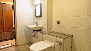 Un baño pequeño con inodoro, lavamanos y espejo.