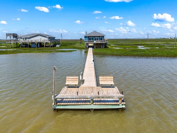 A wooden pier extending into a body of water with a house and a small building at the end. - Fish From Your Own Private Dock, Tranquil Bay Views and Perfect Sunsets (Freeport)