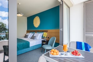 A hotel room with a bed, a table with fruit and juice, and a view of the outdoors. - Hotel Nestos (Dugi Rat)