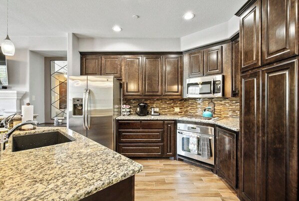 Enjoy cooking in this well-equipped kitchen with a sink, oven, and refrigerator.