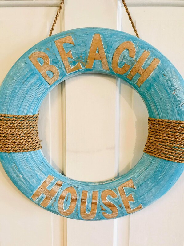 A circular sign with the words 'BEACH HOUSE' in the center.