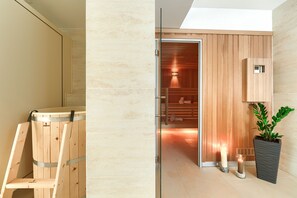 A modern bathroom with a sauna, a glass shower enclosure, and a potted plant. - Welle Resort (Kolobrzeg)