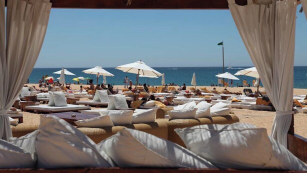 A beachside lounge area with sun loungers, white umbrellas, and a view of the sea. - HEC Beach Apartment Marina Vilamoura, sea side, pool, golf, beach, boat trips,  (Quarteira)