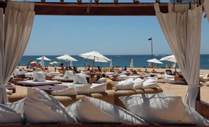 A beachside lounge area with sun loungers, white umbrellas, and a view of the sea. - HEC Beach Apartment Marina Vilamoura, sea side, pool, golf, beach, boat trips,  (Quarteira)