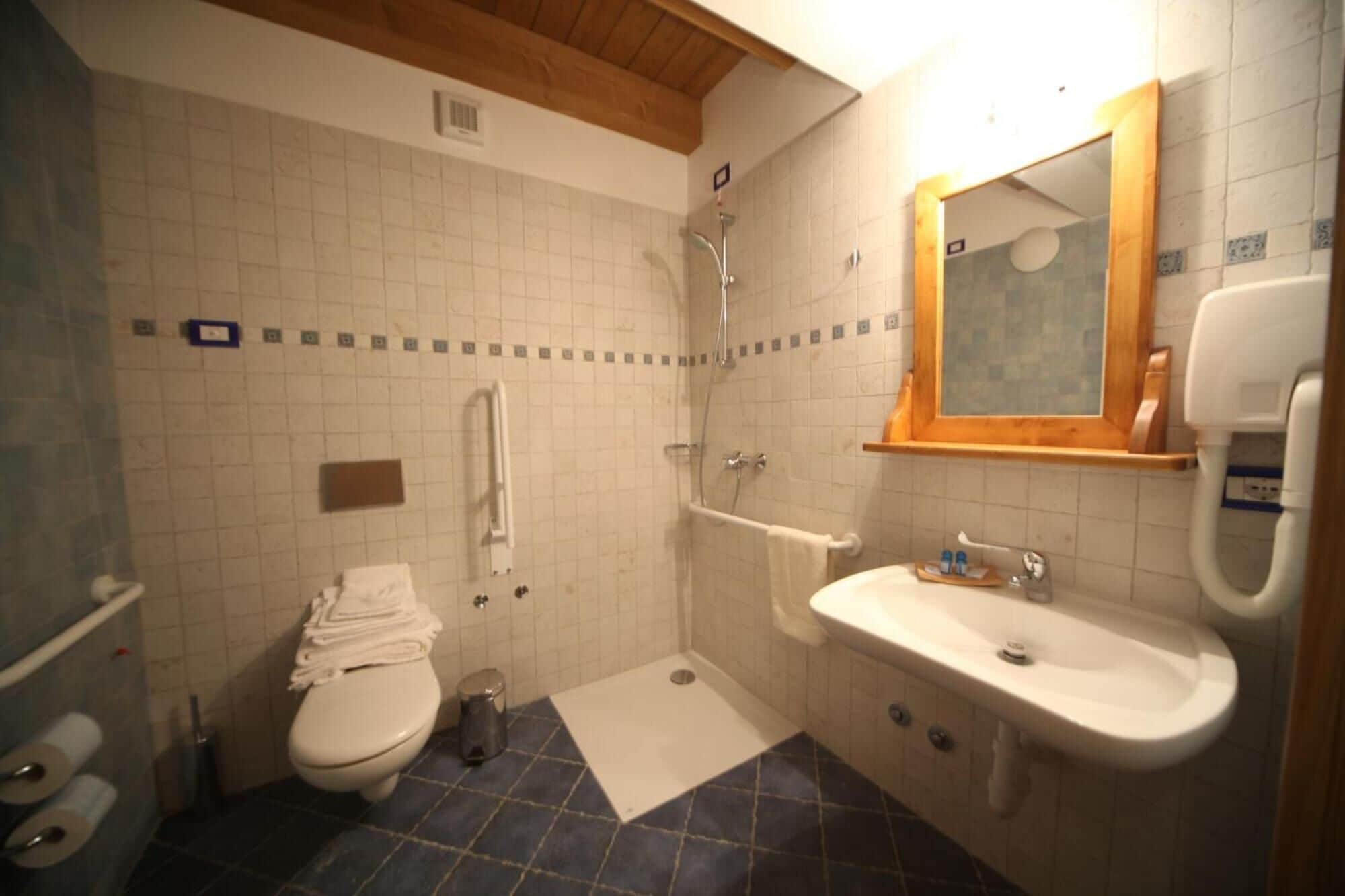 Un bagno piccolo con il water, lavandino e doccia.