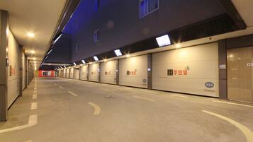 Una larga hilera de puertas de garaje con números iluminados, que señalan los espacios de estacionamiento.
