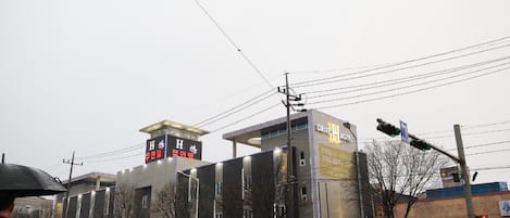Un edificio de varios pisos con letrero de hotel y restaurante.