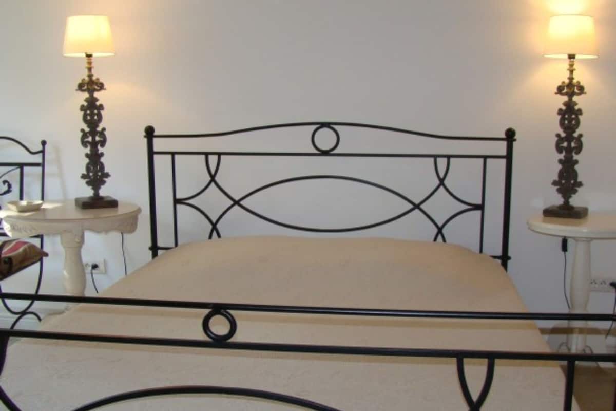 A bed with a metal frame and two bedside tables with lamps.