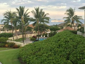 A residential area with a swimming pool, palm trees, and houses with a view of the ocean. - Oceanview Townhome w/ Pool Near Beaches & Shops (Kailua-Kona)