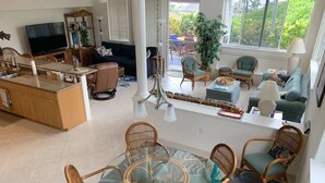 A spacious living area with a kitchen, dining table, and seating.