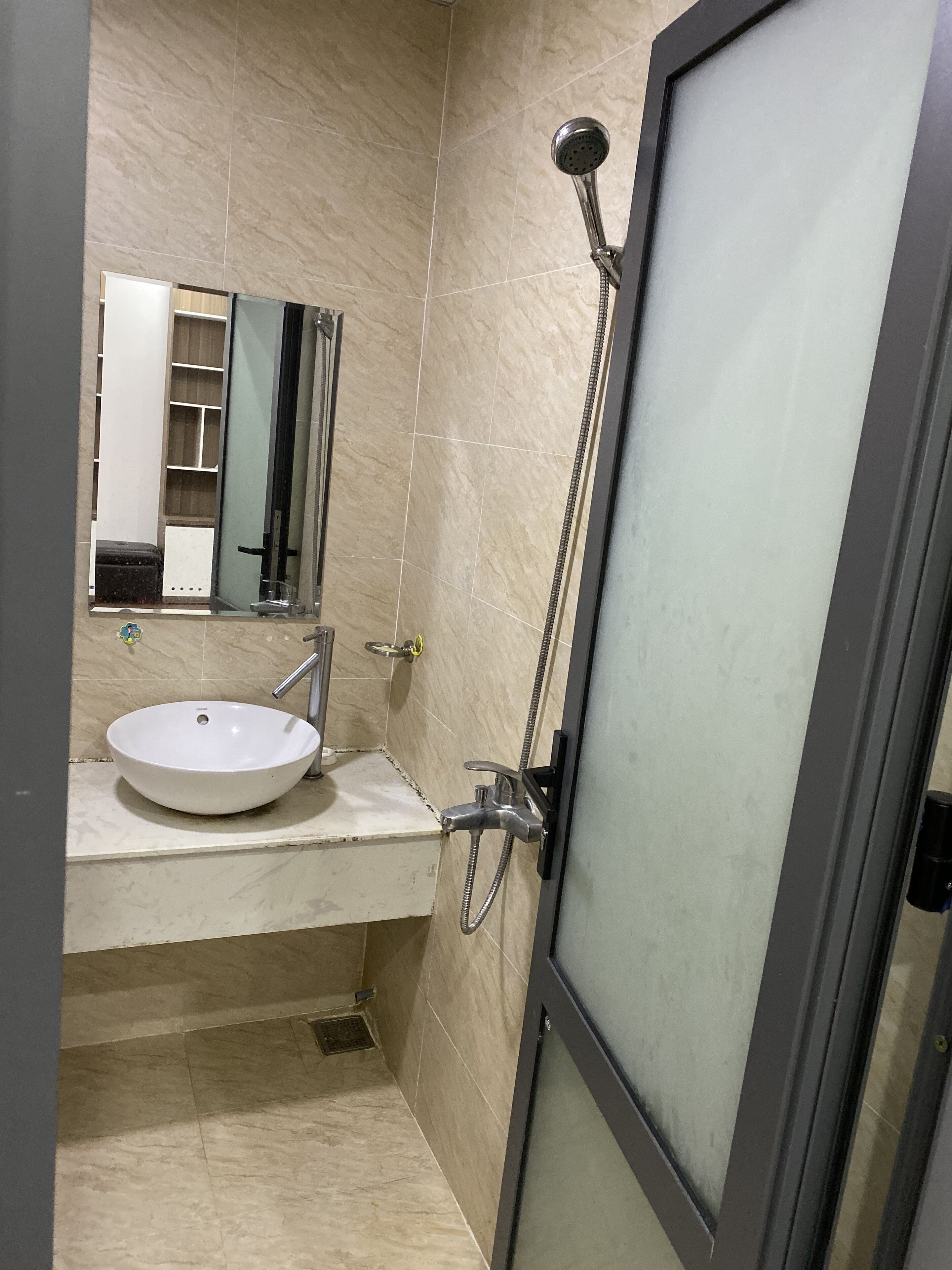 A bathroom with a white sink, a mirror, and a shower.
