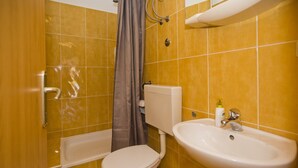 Un baño con inodoro, lavabo y ducha.