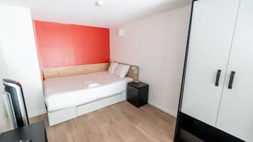 Un dormitorio con cama, mesita de noche, armario y un calentador.