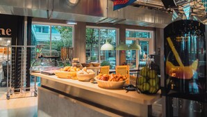 A buffet area with various food items, a glass display case, and a window view. - Ecla Paris Massy Palaiseau (Palaiseau)