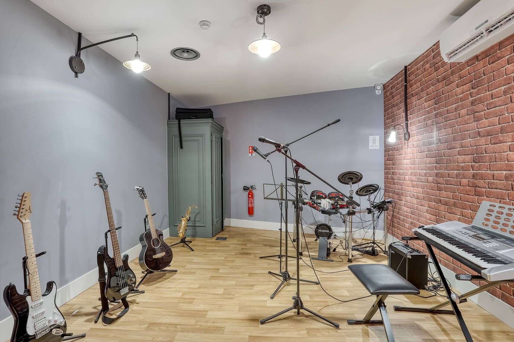 A music studio with various instruments, a keyboard, and a drum set.