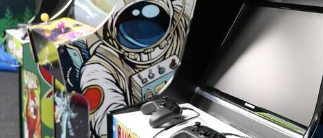 Una hilera de máquinas de arcade con diseños de temática espacial y un juego de Super Mario.