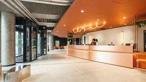 A modern reception area with a curved counter, glass doors, and a visible outdoor view. - Ecla Paris Massy Palaiseau (Palaiseau)