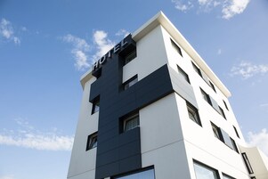 Un edificio moderno de hotel con un llamativo letrero que dice 'HOTEL' en la parte superior.