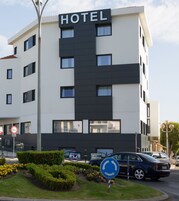 Un moderno edificio de hotel con un cartel que indica una rotonda más adelante.