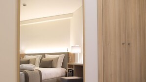 Un dormitorio con cama, mesita de noche, lámpara y armario.