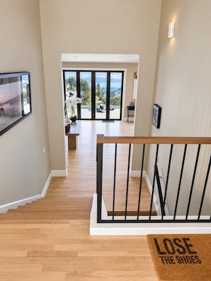 A staircase leading to a living area with a view of the outdoors. - Lake Panorama Villa - Central Luxury Hot Tub Views (Queenstown)