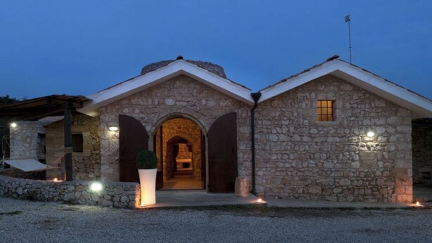 A stone building with a central arched entrance, flanked by two smaller structures. - Monolocale del Sole (Morciano di Leuca)