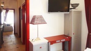A room with a desk, a lamp, a television, and a wardrobe. - VersoSud - Casa Torre San Giovanni 17 (Ugento)