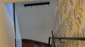 A staircase with carpeted steps, wooden handrails, and patterned wallpaper on the walls. - Home Trietje Ghent (Ghent)