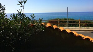 A coastal view with a clear sky, a wooden fence, and potted plants. - Emma's Villa facing the sea with swimming pool (Racale)