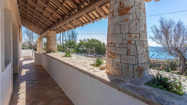 A covered outdoor area with stone pillars and a tiled floor, leading to a view of the sea. - Emma's Villa facing the sea with swimming pool (Racale)