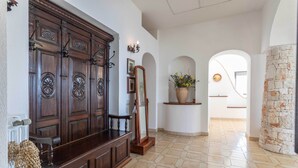 A hallway with a wooden bench, a mirror, and a potted plant. - Emma's Villa facing the sea with swimming pool (Racale)