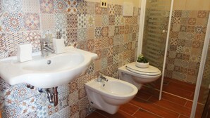Un baño con dos lavamanos, un bidé y un inodoro.