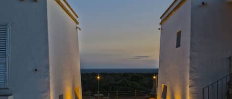 A building with a view of the sea at dusk.