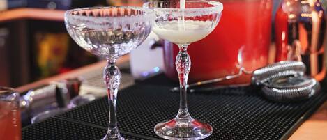 A bartender pouring a drink into a glass.