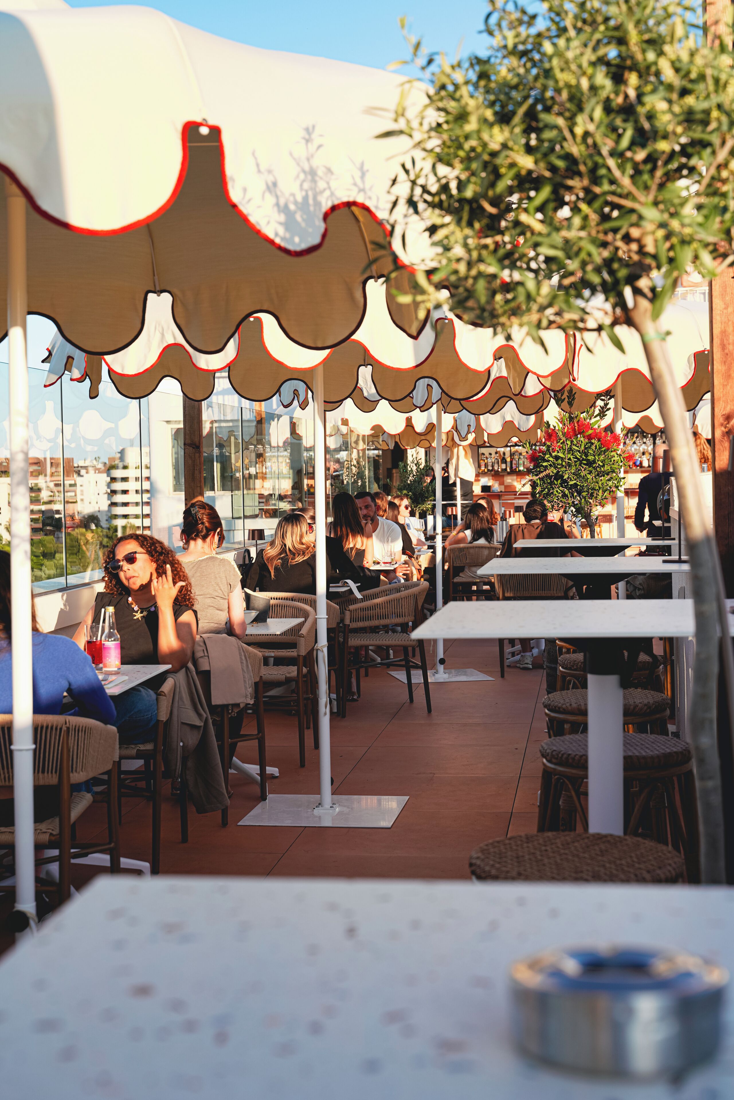 Un café al aire libre con mesas y sillas bajo un toldo.