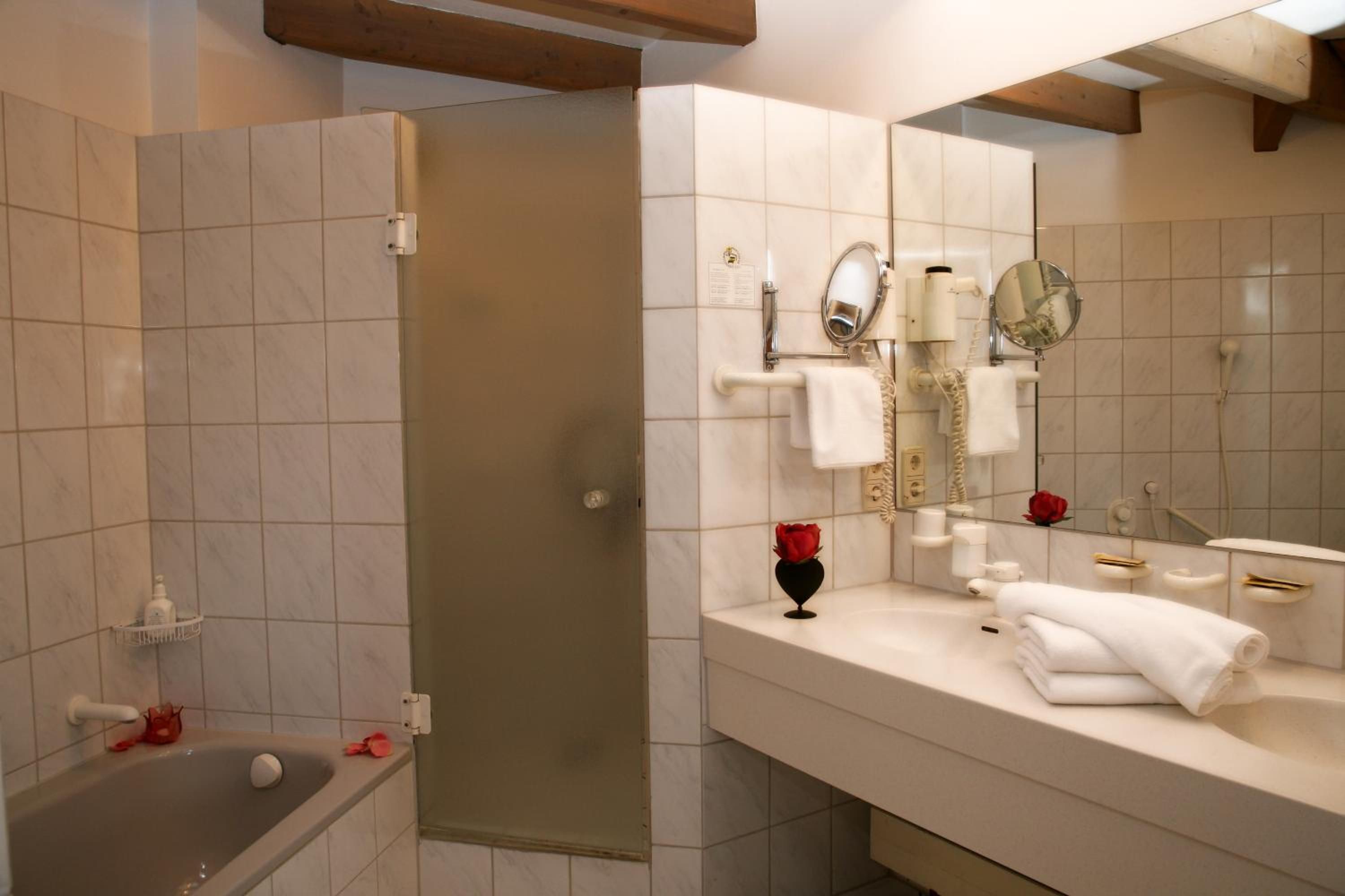Un baño moderno con bañera, ducha y tocador con espejo.